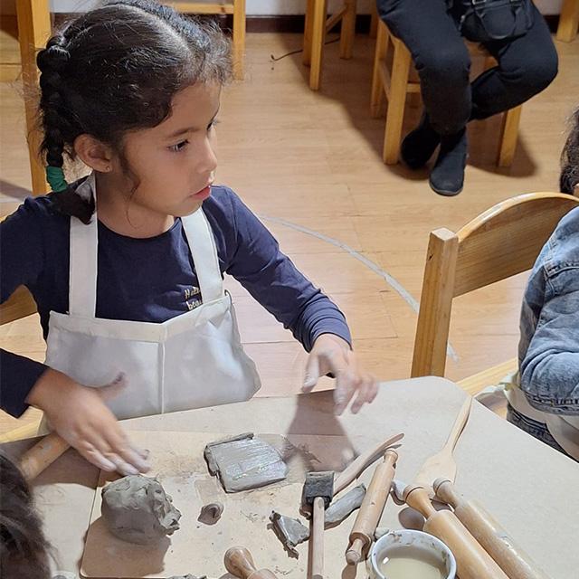niña en taller de arcilla en español